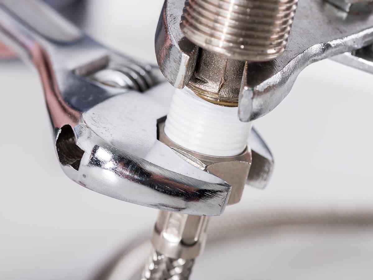 Adjustable wrenches tightening a tap connector